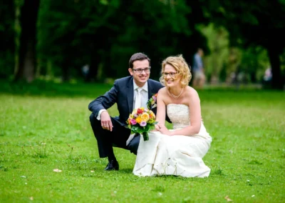 Brautpaar laechelnd im Gruenen bei Hochzeitsfotografie im Englischen Garten Muenchen. Hochzeit in Schwabing.