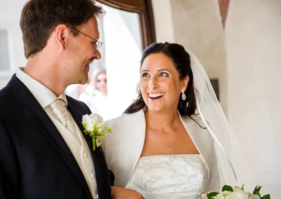 Brautpaar laechelt in Aufkirchen bei kirchlicher Trauung. Hochzeitsfotograf dokumentiert den besonderen Moment.