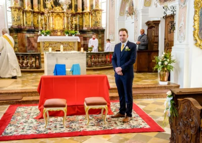 Mann im Anzug vor Altar in Kirche während kirchlicher Trauung einer Hochzeit im Leitzachtal.