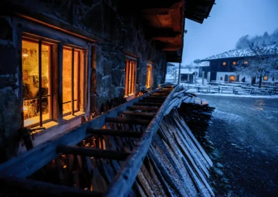 Ein schneebedecktes Gebaeude bei Nachtbeleuchtung, Hochzeitsfoto im Wasmeier Museum Schliersee.