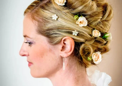 Braut mit Blumenschmuck im Haar bei Hochzeitsfoto, aufgenommen in Kloster Seeon im Chiemgau, elegantes Hochzeitsportrait.