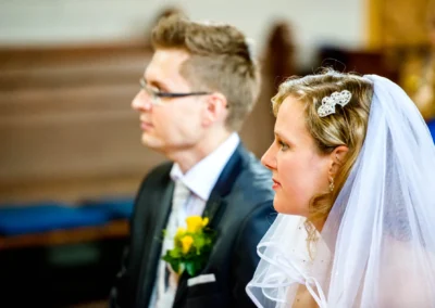 Brautpaar in der evangelischen Friedenskirche, nahe Starnberger See, waehrend der kirchlichen Trauung fotografiert.