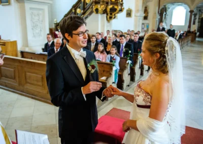 Braut und Bräutigam tauschen Ringe in der Kirche des Klosters Benediktbeuern während der Hochzeitszeremonie.