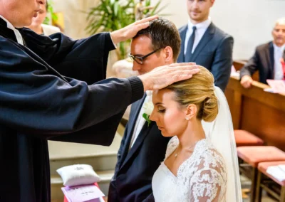 Priester segnet Hochzeitspaar bei kirchlicher Trauung in Sankt Martin Waakirchen, festgehalten von Hochzeitsfotograf.