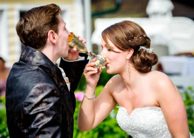 Brautpaar beim Trinken aus Kelchen bei einer Hochzeit am Starnbergersee, festgehalten von einem Hochzeitsfotograf.