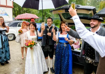 Hochzeitsfoto am Standesamt Herrsching: Feiernde Gaeste in Tracht mit Sektglaesern bei einer standesamtlichen Trauung.
