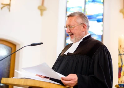 Pastor bei der kirchlichen Trauung in Garmisch, liest Gebete. Hochzeitsfotograf aus Oberbayern.