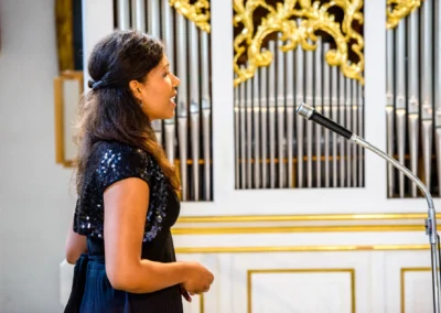 Kirchliche Trauung nahe Tegernsee, Saengerin singt vor Orgel in Waakirchen während Hochzeit, Hochzeitsfotografie.