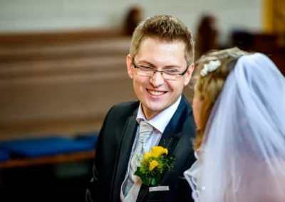 Bräutigam lächelt während der kirchlichen Trauung in der evangelischen Friedenskirche. Hochzeitsfoto in Starnberg.