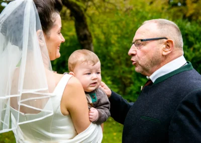 Braut mit Kind und aelterem Mann bei der kirchlichen Trauung in Feldafing am Starnberger See. Hochzeitsfoto.