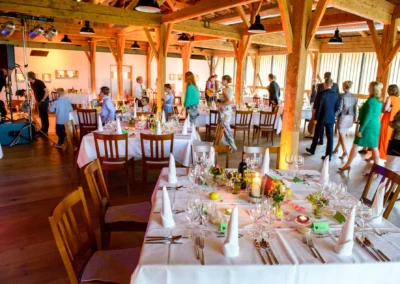 Elegante Hochzeitslocation im Moarhof, Rossholzen. Festliche Tische mit Blumen und Kerzen auf Hochzeit dekoriert.