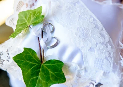 Eheringe auf einem weißen Spitzentuch mit gruenen Blaettern bei einer kirchlichen Trauung nahe Muenchen.