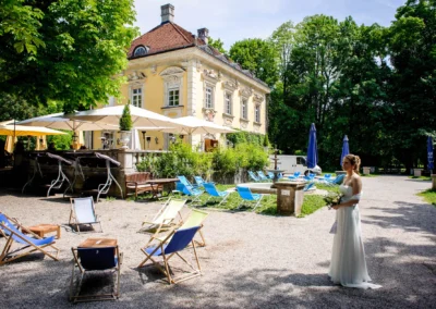 Braut im Garten vor gelbem Herrenhaus bei einer Hochzeit im Luitpoldpark Muenchen. Hochzeitsfotografie in Schwabing.