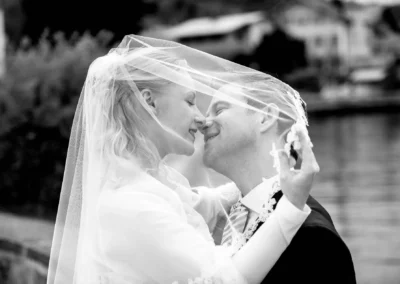 Brautpaar im schwarz-weiß Foto am Tegernsee, Hochzeitsfotografie mit Schleier, romantische Hochzeitsreportage.