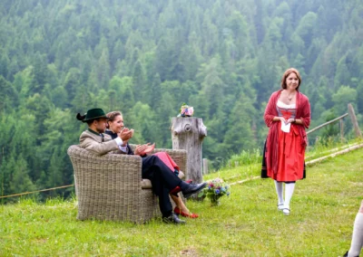 Brautpaar sitzt neben Traurednerin bei freier Trauung im Sillberghaus, umgeben von grünen Bergen. Hochzeitsreportage.