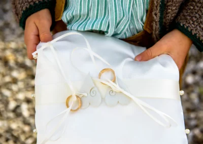 Kind haelt Kissen mit Trauringen bei kirchlicher Trauung in Valley-Unterdarching, festgehalten von Hochzeitsfotograf.