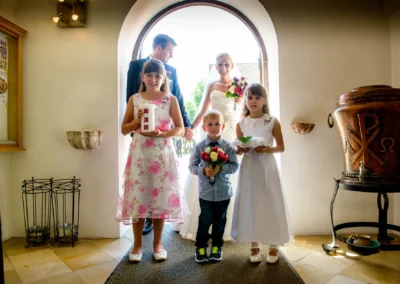 Brautpaar und Kinder in Kirche bei Hochzeit nahe Muenchen, festliche Szene. Hochzeitsfoto von Hochzeitsreportage.