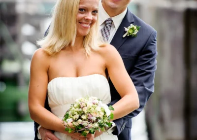 Brautpaar laechelt am Steg am Starnberger See, romantische Hochzeitsfotografie bei einer Hochzeit.