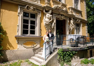 Brautpaar vor historischem Gebaeude beim Bamberger Haus in Muenchen, perfekte Hochzeitsreportage bei sonnigem Wetter.