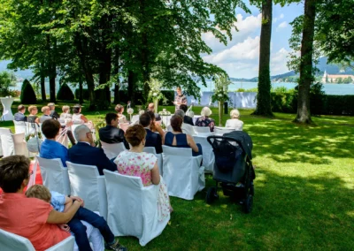 Gartenhochzeit am Tegernsee mit Blick auf den See, Hochzeitsreportage mit freier Trauung unter Bäumen.