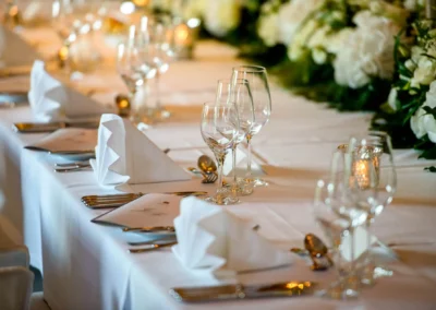 Elegante Hochzeitstafel mit weißen Servietten, Weingläsern und Blumen im Hotel Überfahrt Rottach Egern am Tegernsee.