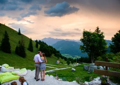 Paar bei Hochzeitsreportage auf der Wuhrsteinalm im Chiemgau bei Sonnenuntergang, mit Alpen im Hintergrund. Hochzeitsfoto.