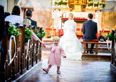 Kleinkind in rosa Kleid bei kirchlicher Trauung, Kloster Seeon im Chiemgau, Hochzeitsreportage.