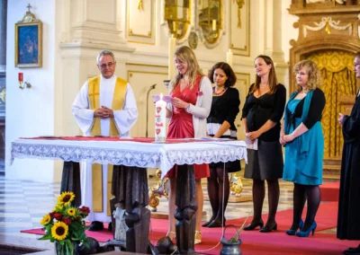 Hochzeitsfoto von kirchlicher Trauung im Kloster Benediktbeuern, Personen versammeln sich um einen Altar.