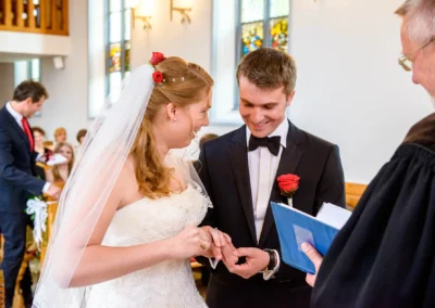 Braut und Braeutigam tauschen Ringe in Kirche bei Hochzeit in Garmisch. Hochzeitsfotografie in Oberbayern.