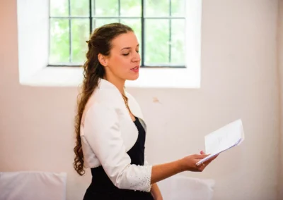 Frau singt bei kirchlicher Trauung in gut Thurnsberg, Oberbayern. Hochzeitsfoto mit elegantem Outfit.