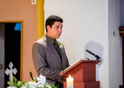 Mann im Anzug liest waehrend der kirchlichen Trauung in Muenchen aus einem Buch. Hochzeit in Pasing.