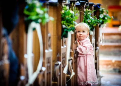 Kleines Kind in rosa Kleid bei einer kirchlichen Trauung im Kloster Seeon im Chiemgau, Hochzeitsfotografie.