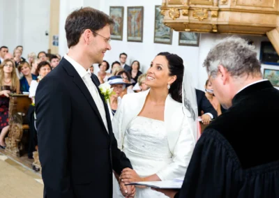 Brautpaar bei kirchlicher Trauung in Aufkirchen am Starnberger See, umringt von Gaesten, Hochzeitsfotograf.