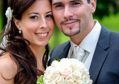 Brautpaar beim Hochzeitsfoto im Gruenen in Arget mit Brautstrauss aus weissen Rosen, aufgenommen vom Hochzeitsfotografen.