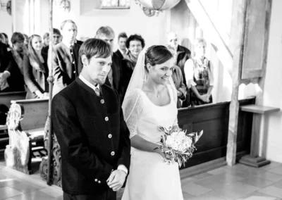 Brautpaar steht bei kirchlicher Trauung in Valley. Hochzeitsreportage zeigt Paar mit Brautstrauss in der Kirche.