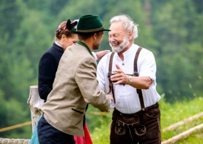 Lachende Gaeste in traditioneller Tracht bei Berg-Hochzeit in Bayrischzell, festgehalten in Hochzeitsreportage.