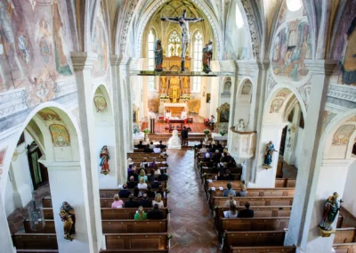 Kirchliche Trauung im Kloster Seeon Oberbayern. Blick auf Altar und Gaeste. Hochzeitsfotograf spezialisiert.