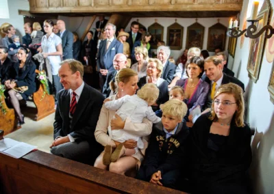 Gäste sitzen in einer Kirche bei einer Hochzeit auf Gut Thurnsberg. Hochzeitsreportagen in der Umgebung von Freising.