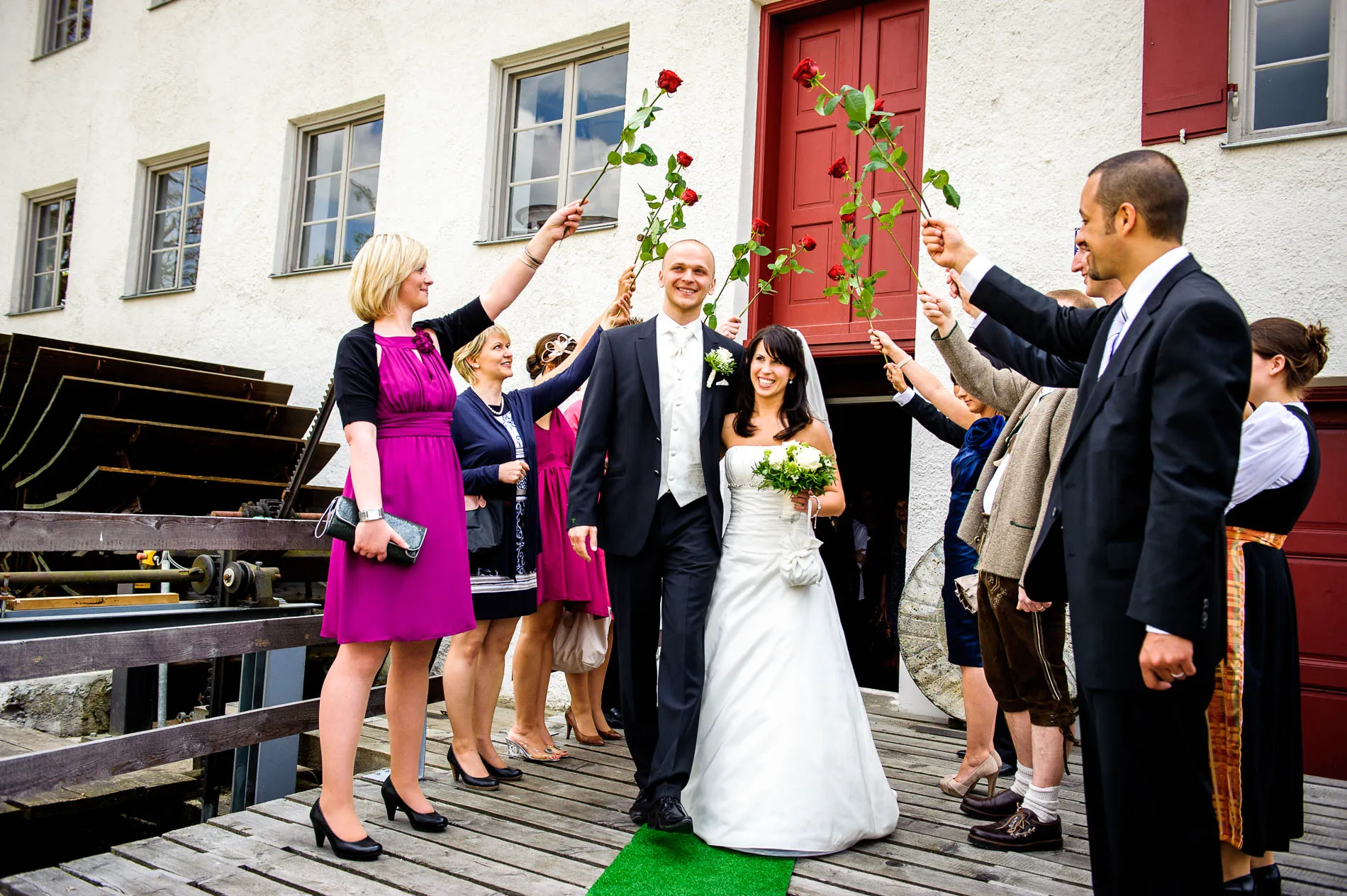 Brautpaar verlässt standesamtliche Trauung, Gäste mit Rosen, Krailling. Hochzeitsfotograf nahe München.