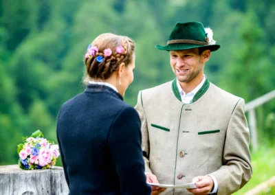 Brautpaar bei einer freien Trauung im Sillberghaus, traditionell gekleidet, mit Blumenstrauss im Hintergrund.