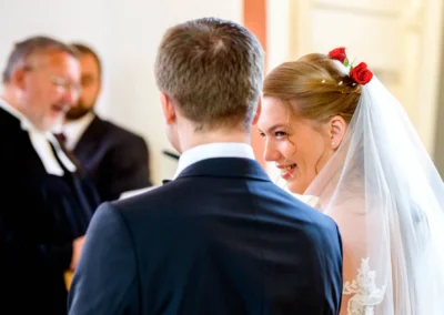 Brautpaar bei der kirchlichen Trauung in Garmisch, lachende Braut mit Schleier, Hochzeitsfotografie in Bayern.