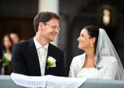 Brautpaar bei kirchlicher Trauung in Aufkirchen, lächelnd und verliebt. Hochzeitsfotograf südlich von München.