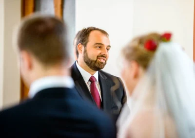 Pfarrer spricht bei kirchlicher Trauung auf Hochzeit in Oberbayern. Hochzeitsfoto von Brautpaar im Vordergrund.