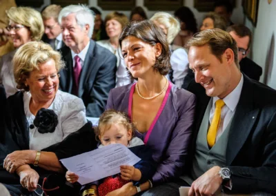 Gäste lachen während der kirchlichen Trauung bei einer Hochzeit auf Gut Thurnsberg, nördlich von Muenchen.
