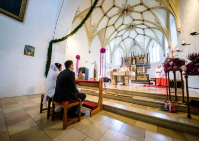 Brautpaar bei kirchlicher Trauung in St. Vitus Gilching, Hochzeitsfotograf fängt feierlichen Moment ein.