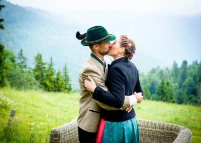 Paar in Tracht bei Hochzeit in Bayrischzell vor Alpenkulisse. Hochzeitsfotografie im Freien.