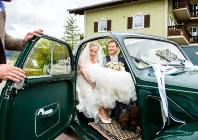 Brautpaar in Oldtimer am Tegernsee, Hochzeit aufgenommen von Hochzeitsfotograf bei stilvoller Hochzeitsreportage.