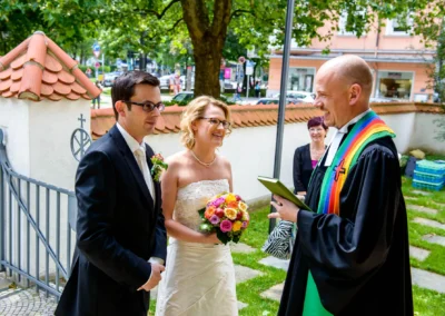 Brautpaar vor der kirchlichen Trauung in der Erlöserkirche Schwabing, Hochzeitsfotograf einfängt glückliche Momente.