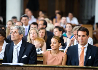 Gäste sitzen in einer Kirche bei einer kirchlichen Trauung in Aufkirchen bei Starnberger See.