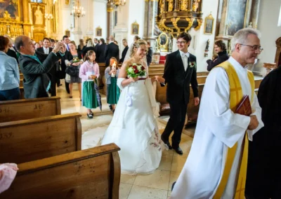 Brautpaar verläßt Kirche bei Trauung in Kloster Benediktbeuern, festgehalten von Hochzeitsfotograf aus München.